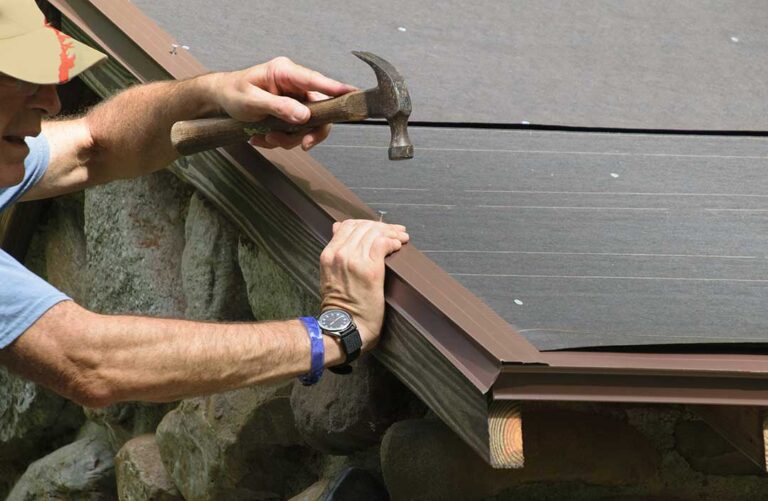 Homeowner viewing asphalt shingles and flashing on a roof after winter weather